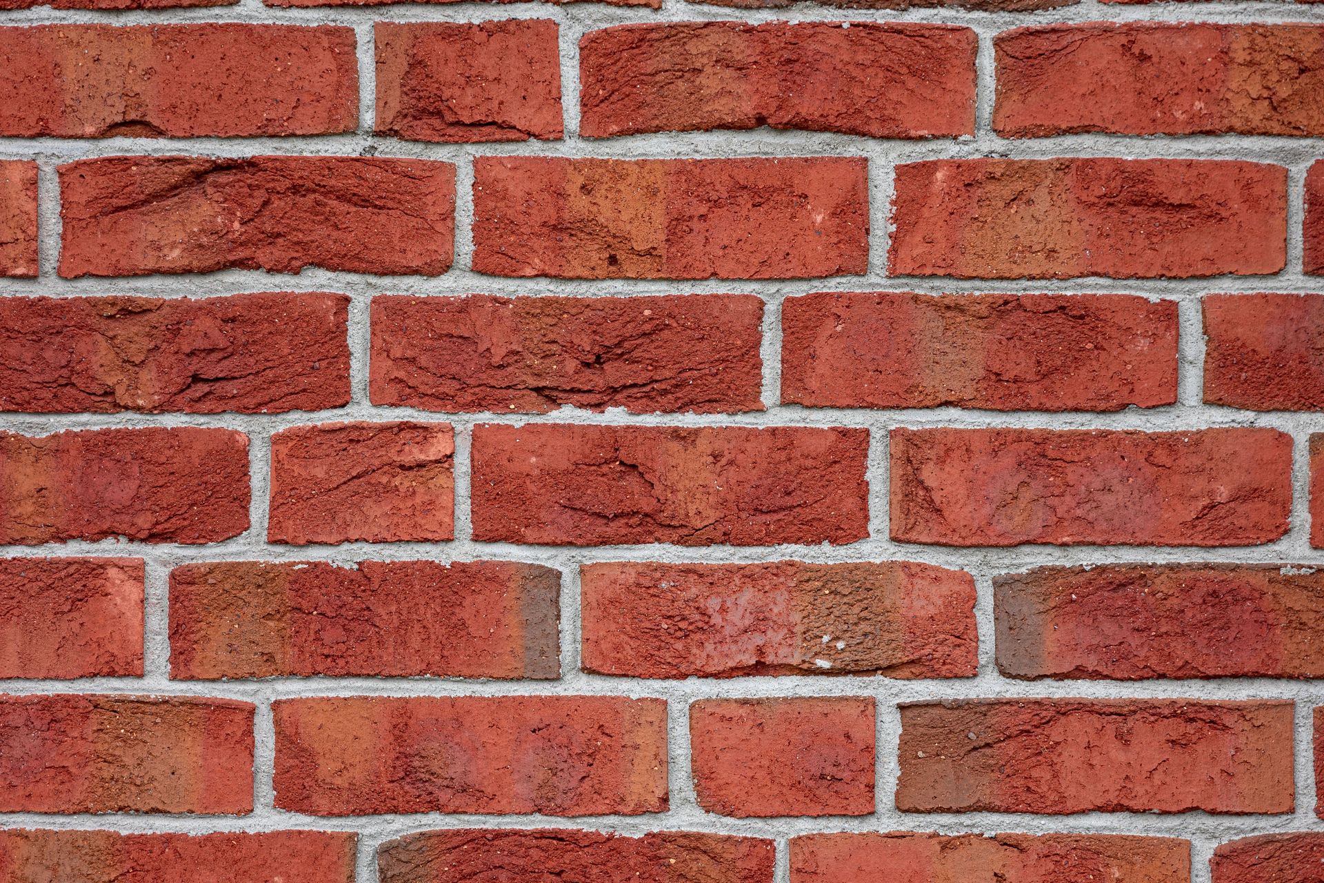 Detailed image of a red brick wall, showcasing texture and urban design pattern.